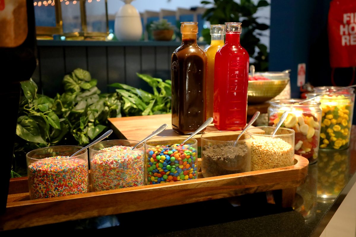 Dessert bar at Twin City Hotel buffet featuring chocolate, strawberry and caramel strips with a variety of toppings including sprinkles, M&M's, ore crumb and crushed nuts.