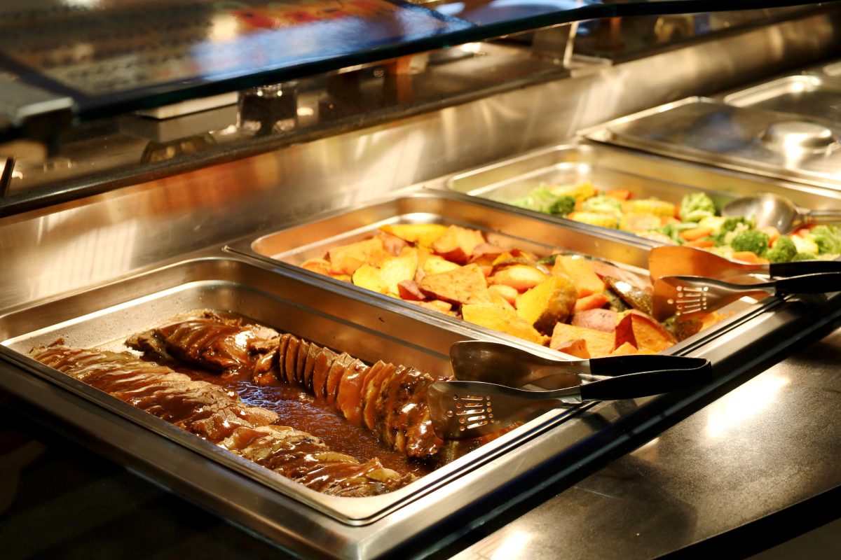 Hot buffet at Twin City Hotel featuring juicy roast beef in gravy, roasted vegetables and steamed mixed greens.