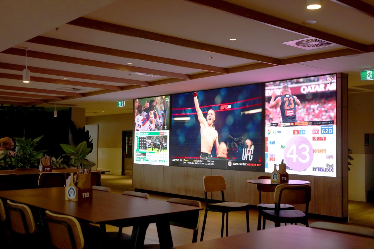 Large screen in the DownTown sports bar at Twin City Hotel for showing live sports in a lively and energetic atmosphere.